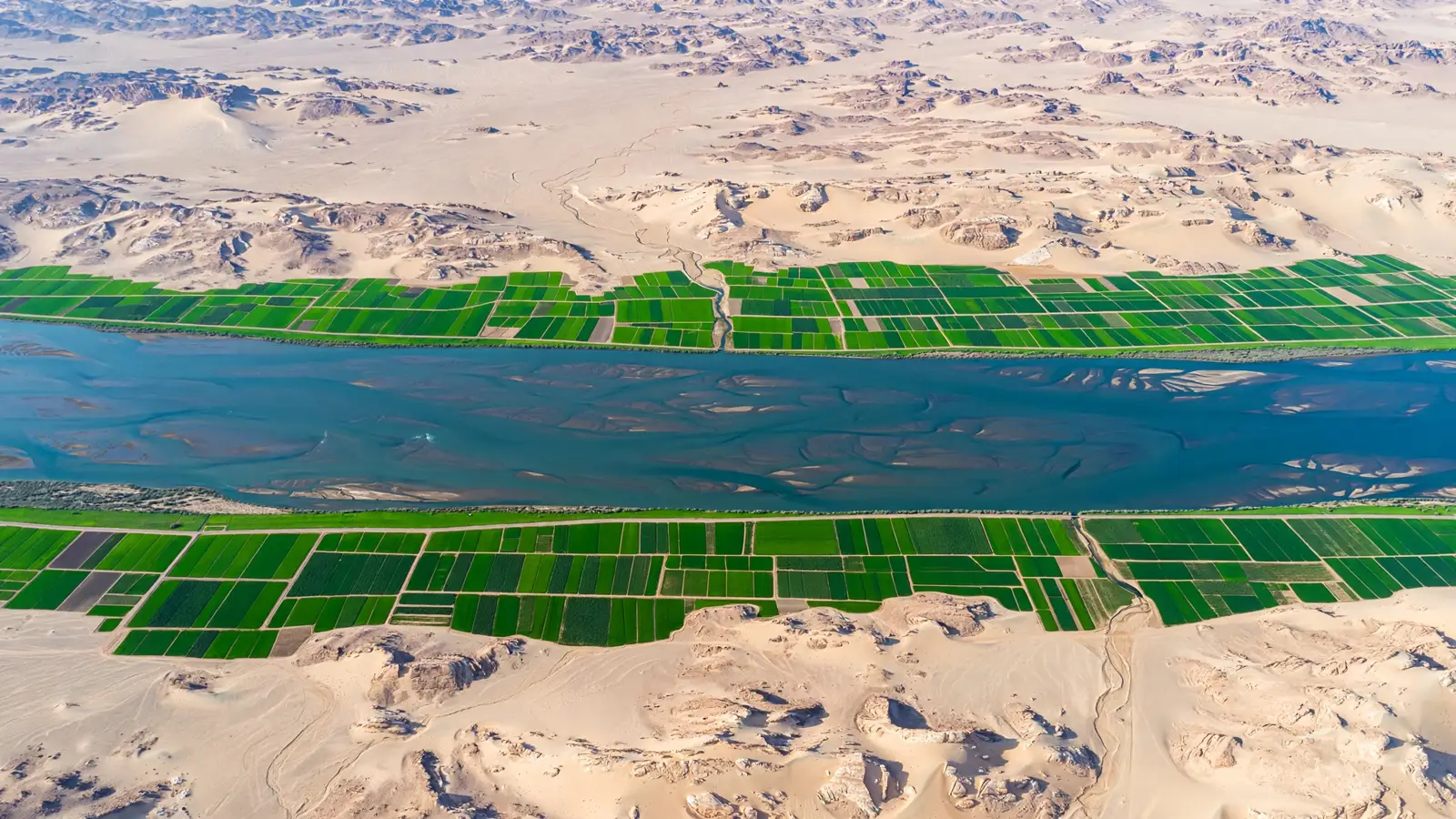 Aerial view of the narrow green Nile floodplain bounded by desert on both sides