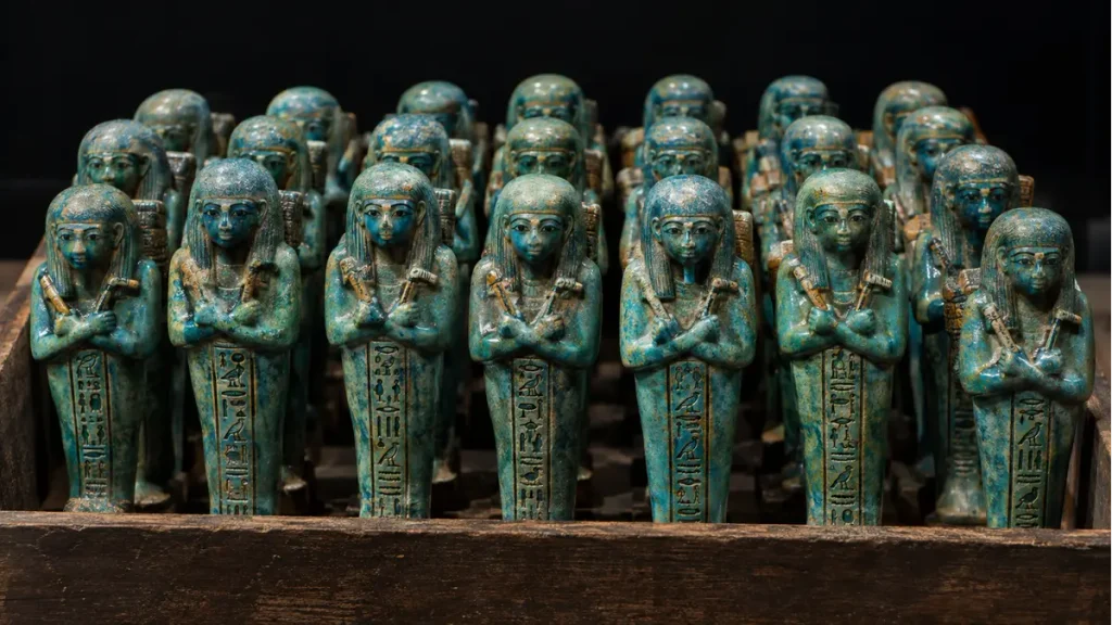 Rows of small blue-glazed mummiform shabti figurines holding hoes